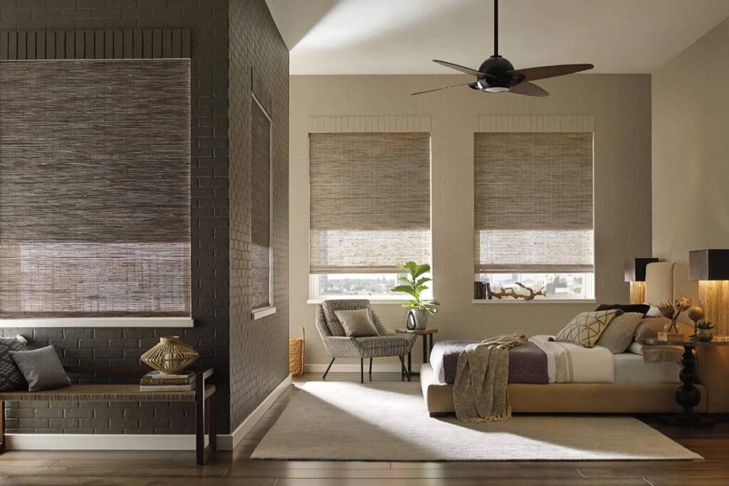 Stylish Hunter Douglas Provenance® Woven Wood Shades on four windows in a cozy bedroom