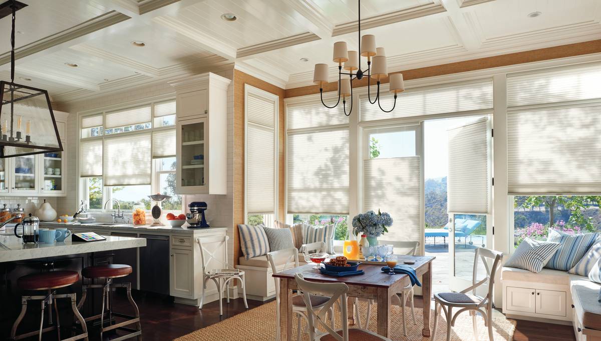 Custom window treatments from Hunter Douglas on several windows in a kitchen and dining area