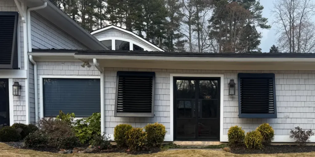 A home's exterior windows featuring black handcrafted shutters, installed by Metro Shutters & Blinds near Marietta, GA