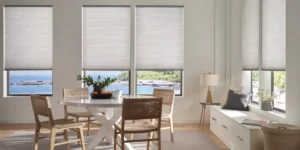 Hunter Douglas Duette® Cellular Shades on several windows in a dining nook with an airy design